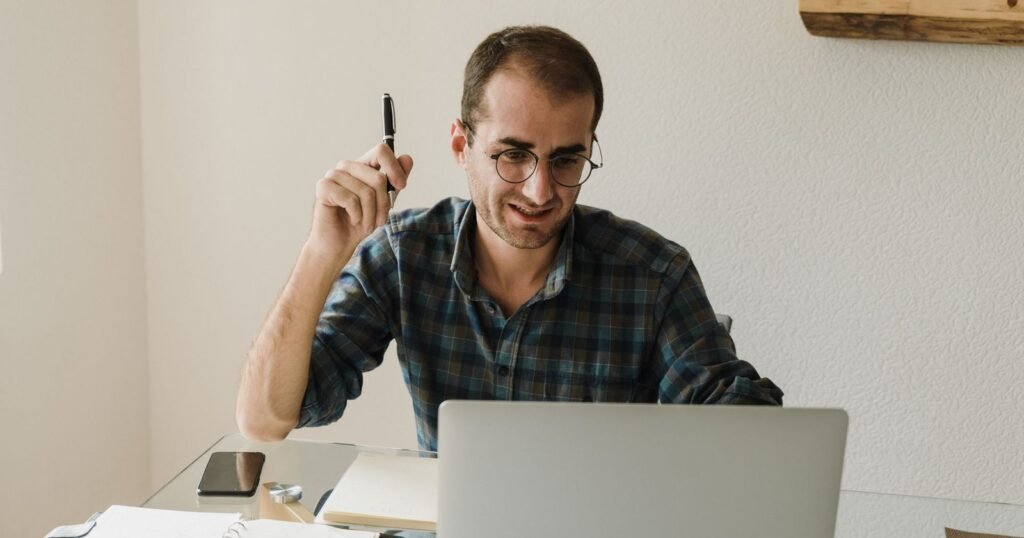 Self-employed man at his desk with a laptop and notebook, working on his figures
