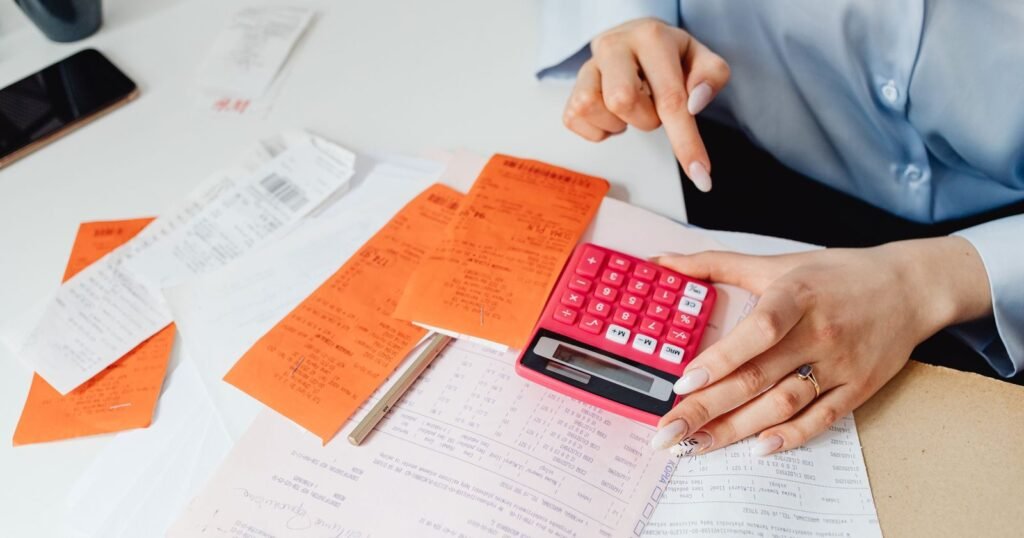 Sole trader going through business receipts with a calculator